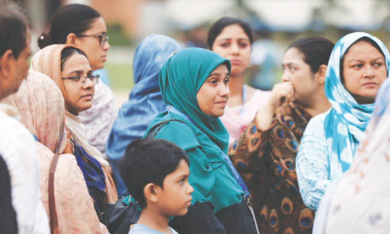 WOMEN visit the scene of the crash in Dhaka on Tuesday.&mdash;Reuters