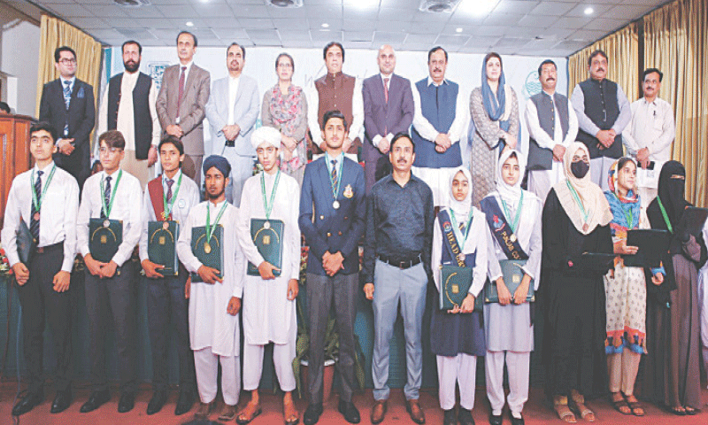 Position holders in Rawalpindi board&rsquo;s SSC exam pose with Railways Minister Hanif Abbasi, MNA Malik Ibrar and other officials of the board during a ceremony at Fatima Jinnah Women University in Rawalpindi on Thursday. &mdash; White Star