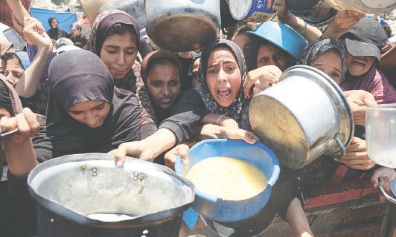 Palestinians gather to receive food from a charity kitchen as hunger crisis worsens in Gaza City.&mdash;Reuters