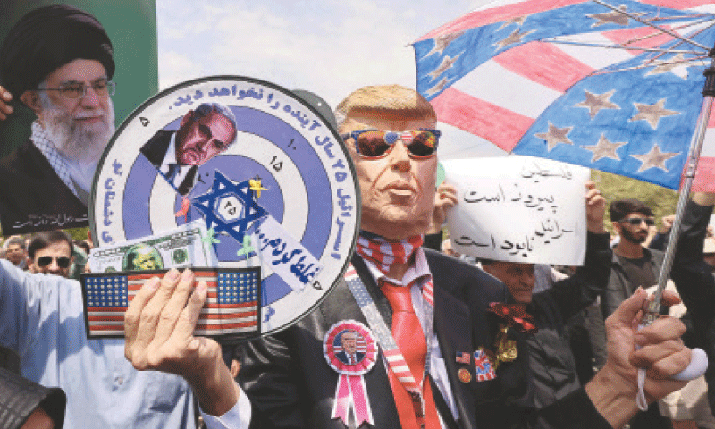 TEHRAN: Wearing a mask depicting US President Donald Trump, a demonstrator holds placards during a rally to express solidarity with Palestinians.&mdash;AFP