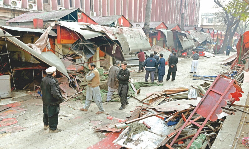 Bystanders stand near razed kiosks and structures at the Melody Market in Islamabad after an anti-encroachment operation by the CDA | White Star