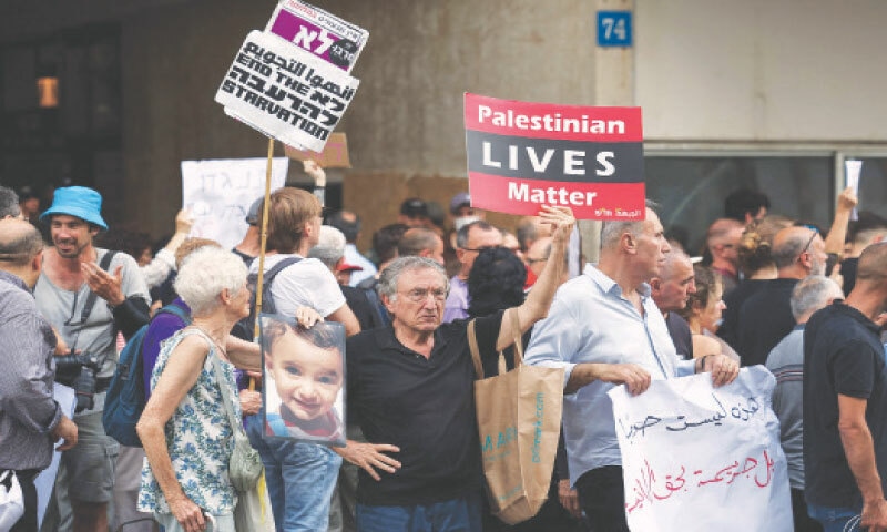 TEL AVIV: People holding placards protest against Israel&rsquo;s war in Gaza, in front of the US consulate. UN agencies have warned that the besieged Palestinian territory is on the brink of a full-blown famine.&mdash;AFP