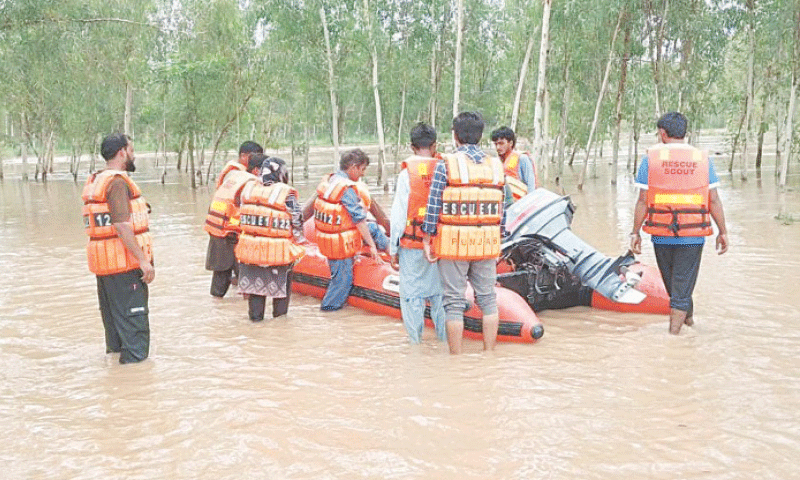 NAROWAL: People trapped due to a torrential flood in the Baein rainwater drain being rescued. &mdash; Dawn