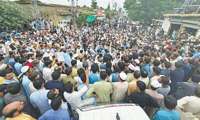 Residents stage a sit-in at Umary Chowk, Lowi Mamund, on Wednesday. &mdash; Dawn