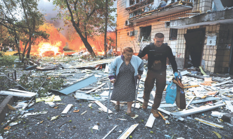 A WOMAN receives assistance as she leaves an apartment building hit by Russian missiles and drones.—Reuters