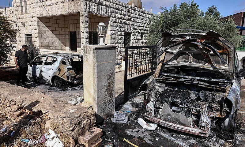 People inspect the damage after an Israeli settler attack at dawn that torched a house and nearby cars and led to the reported death of a Palestinian man by asphyxiation, in Silwad town northeast of Ramallah in the occupied West Bank on July 31, 2025. — AFP
