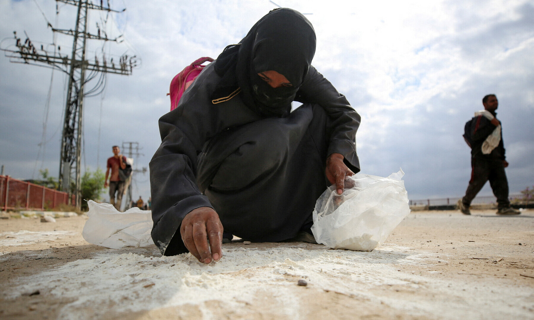  A woman collects flour from the ground as Palestinians receive aid supplies from the US-backed Gaza Humanitarian Foundation (GHF), in the central Gaza Strip on Aug 1, 2025. &mdash; Reuters/Stringer 