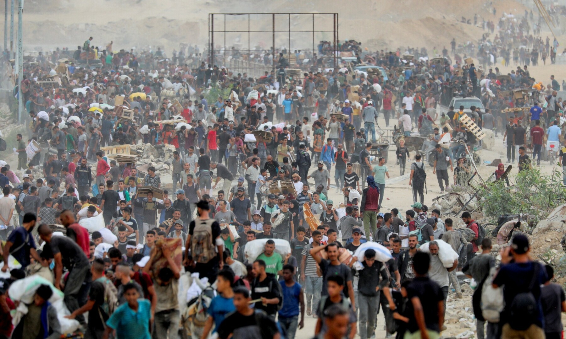  Palestinians carry aid supplies which they received from the US-backed Gaza Humanitarian Foundation (GHF), in the central Gaza Strip on Aug 1, 2025. &mdash; Reuters/Stringer 