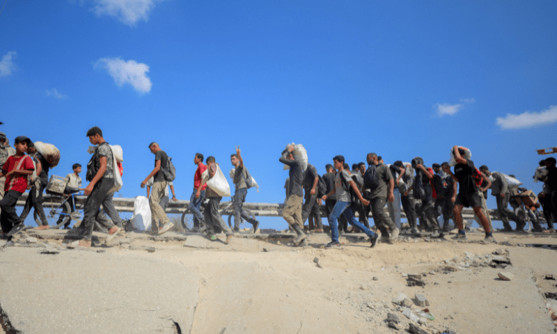  Palestinians carry aid supplies which they received from the US-backed Gaza Humanitarian Foundation (GHF), in the central Gaza Strip on August 4, 2025. &mdash; Reuters 
