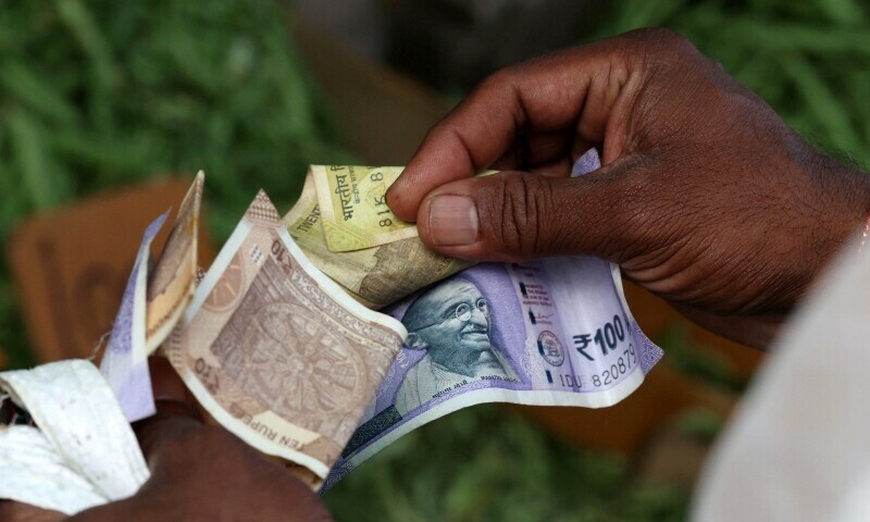 A man counts Indian currency notes at a market in Bengaluru, India, August 1. &mdash; Reuters