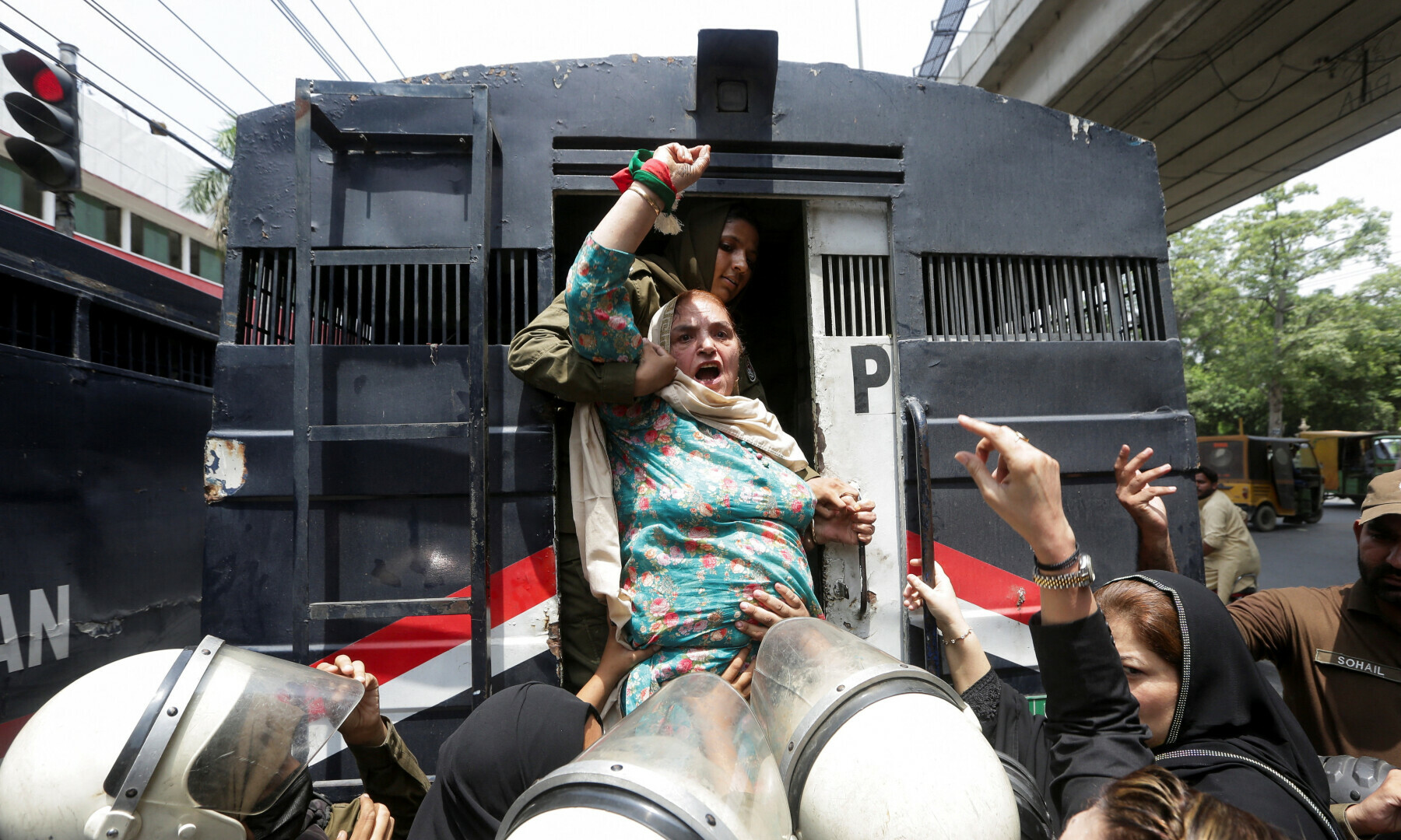 PTI leader Rehana Dar chants slogans while being detained by police officers during a nationwide protest demanding Imran Khan’s release on the second anniversary of his arrest, in Lahore on Aug 5, 2025. — Reuters/Mohsin Raza