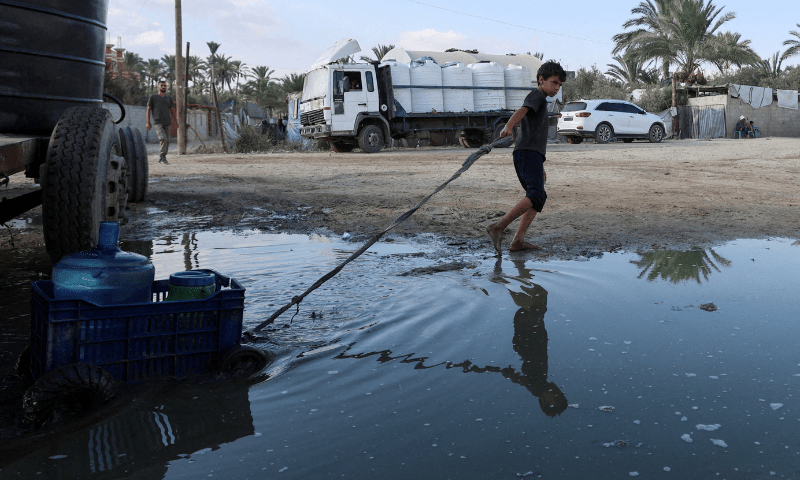  A Palestinian boy drags containers of water amid shortages, at a distribution point in Deir al-Balah in the central Gaza Strip on August 5, 2025. &mdash; Reuters 