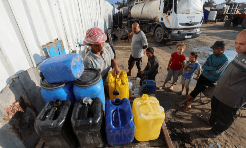  Palestinians collect water amid shortages, at a distribution point in Deir al-Balah in the central Gaza Strip on August 5, 2025. &mdash; Reuters 