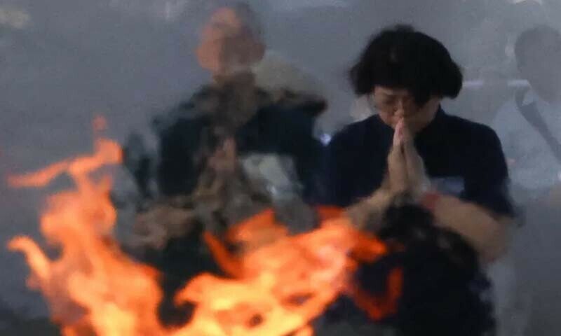 1945 میں امریکا کے ایٹم بم حملوں میں مرنے والوں کی یاد میں جاپانی خاتون ہیروشیما کے پیس میموریل پارک میں موجود ہے &mdash; فوٹو: رائٹرز