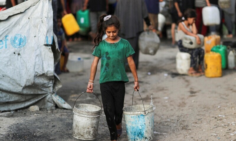 A Palestinian girl carries buckets of water amid shortages, in Gaza City August 6. &mdash; Reuters
