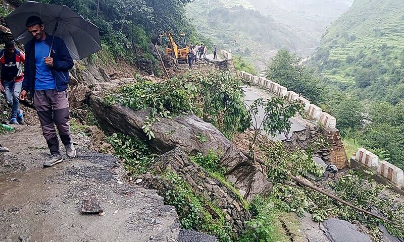 People stand beside a damaged road at a village near Uttarkashi on August 6, 2025, a day after a cloudburst caused a massive mudslide and flash floods in India&rsquo;s Uttarakhand state. &mdash; AFP