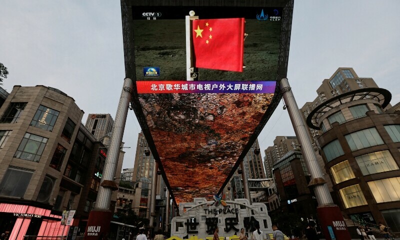 A large screen shows news footage of a Chinese national flag carried by Chang&rsquo;e-6 probe&rsquo;s lander on the far side of the moon, in Beijing, China June 4, 2024. &mdash; Reuters