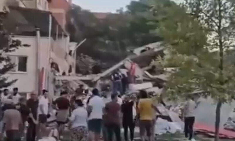 Onlookers gather at the site of a building which collapsed due to an earthquake in Sindirgi, Turkiye on August 10. &mdash; Screengrab via X/@Hurriyet