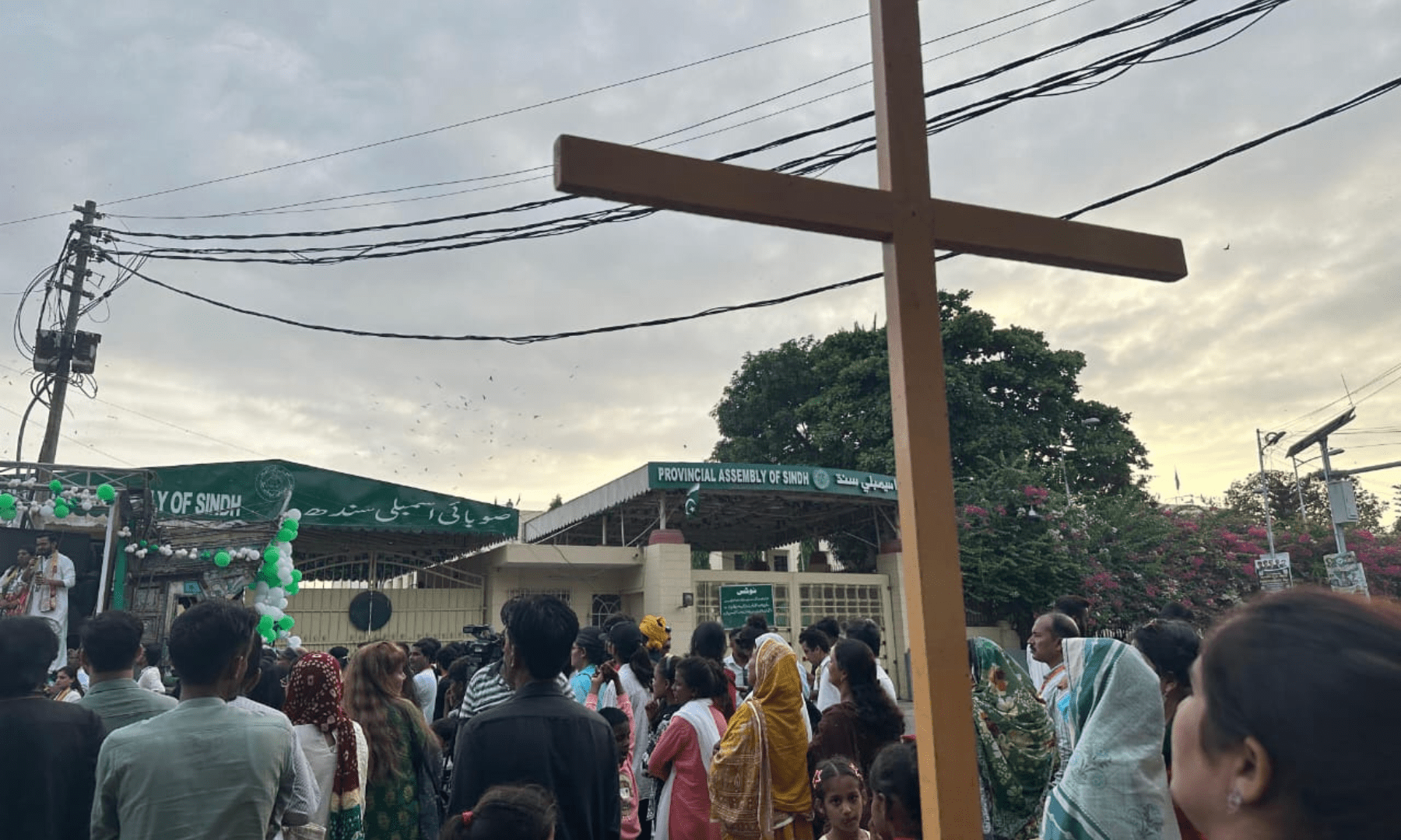 A woman holds up a wooden cross outside the Sindh Assembly at the Minority Rights March held in Karachi on August 10, 2025. — Photo by Shifa