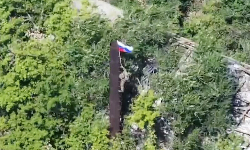 A still image, taken from footage released by the Russian Defence Ministry, shows what it said to be a Russian soldier raising a flag following the capture of Ukraine&rsquo;s Yablunivka (Yablonovka) settlement in the Donetsk region in the course of Russia-Ukraine military conflict, in this image from video released August 12. &mdash; Reuters