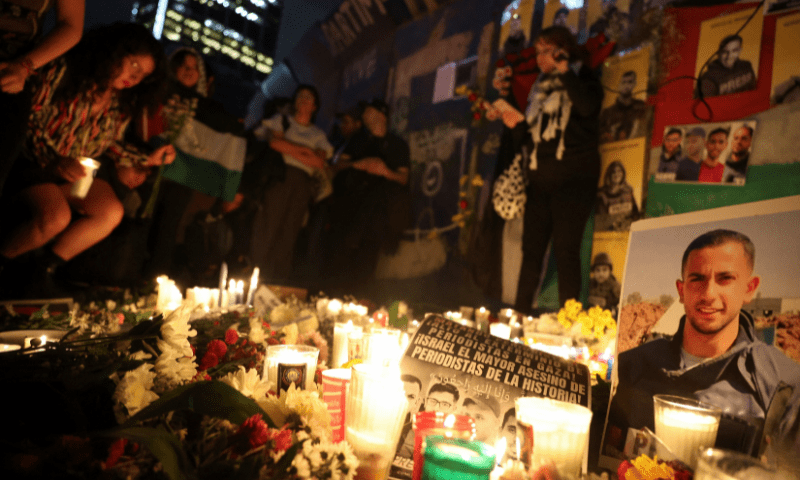  A demonstrator places a candle next to posters, with photos of <em>Al Jazeera</em> journalists killed during an Israeli airstrike in Gaza on Sunday, placed by their colleagues, amid the ongoing conflict between Israel and Hamas, at the Angel of Independence monument, in Mexico City, Mexico on August 12, 2025. &mdash; Reuters 