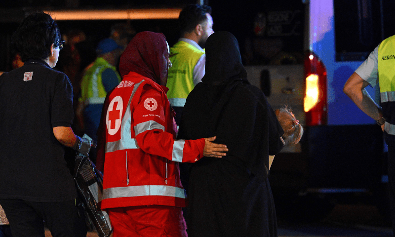  A member of the Italian Red Cross accompanies a woman carrying a child as medics and health personnel welcome Palestinian children from Gaza and their families, after an Italian military plane C130J from Israel landed on August 14, 2025, at Rome&rsquo;s Ciampino airport. &mdash; AFP 