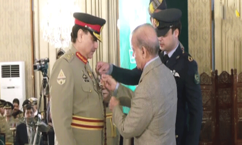 Inter-Services Intelligence Director General Lt Gen Muhammad Asim Malik receives the Hilal-i-Imtiaz from Prime Minister Shehbaz Sharif during a ceremony at the Presidency on August 14. &mdash; DawnNewsTV