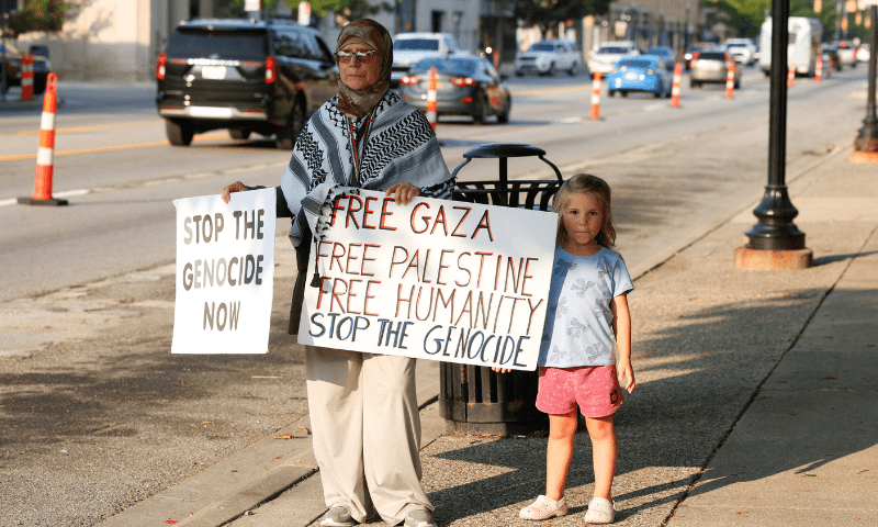 Pro-Palestinian protestor Marion Mourtada holds signs while attending a vigil for Gaza with her granddaughter in Dearborn, Michigan, US on August 14, 2025. &mdash; Reuters 