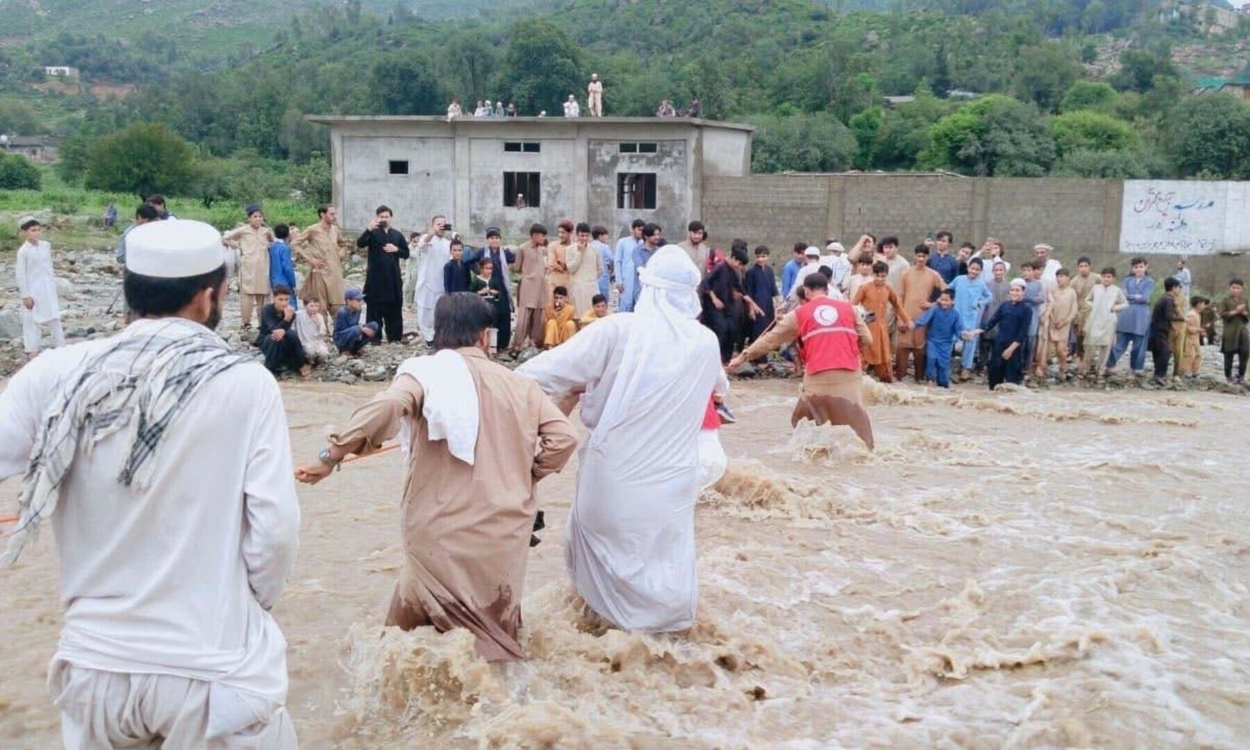  People cross a nullah in flood with the help of ropes in Khyber Pakhtunkhwa’s Bajaur on Aug 15, 2025. — Anwarullah Khan 
