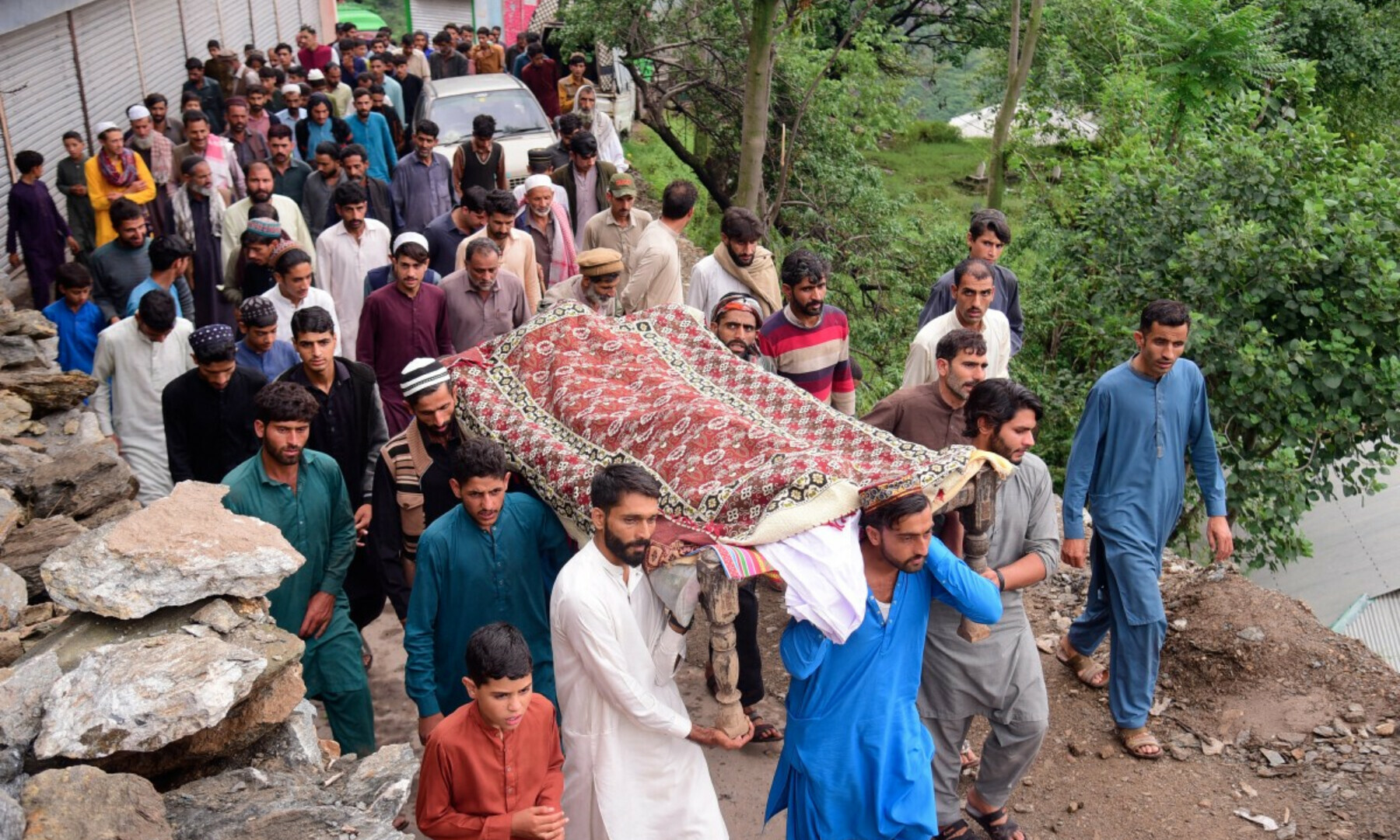  Mourners carry a coffin of a flood victim after flash floods in Naryean Behaak village, some 36 kilometres north of Muzaffarabad, AJK, on Aug 15, 2025. — AFP 