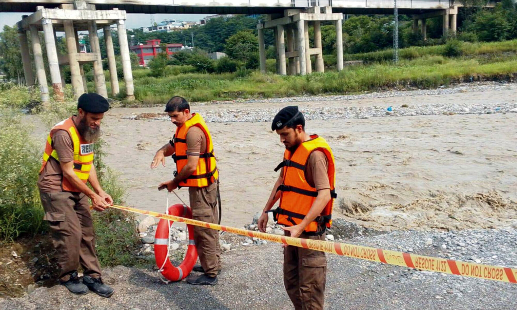  Rescue 1122 officials close the entrance of a river, with rescue personnel deployed at the entry points, to ensure people’s safety during flash floods caused by heavy rains, in KP’s Abbottabad on Aug 15, 2025. — PPI Images 