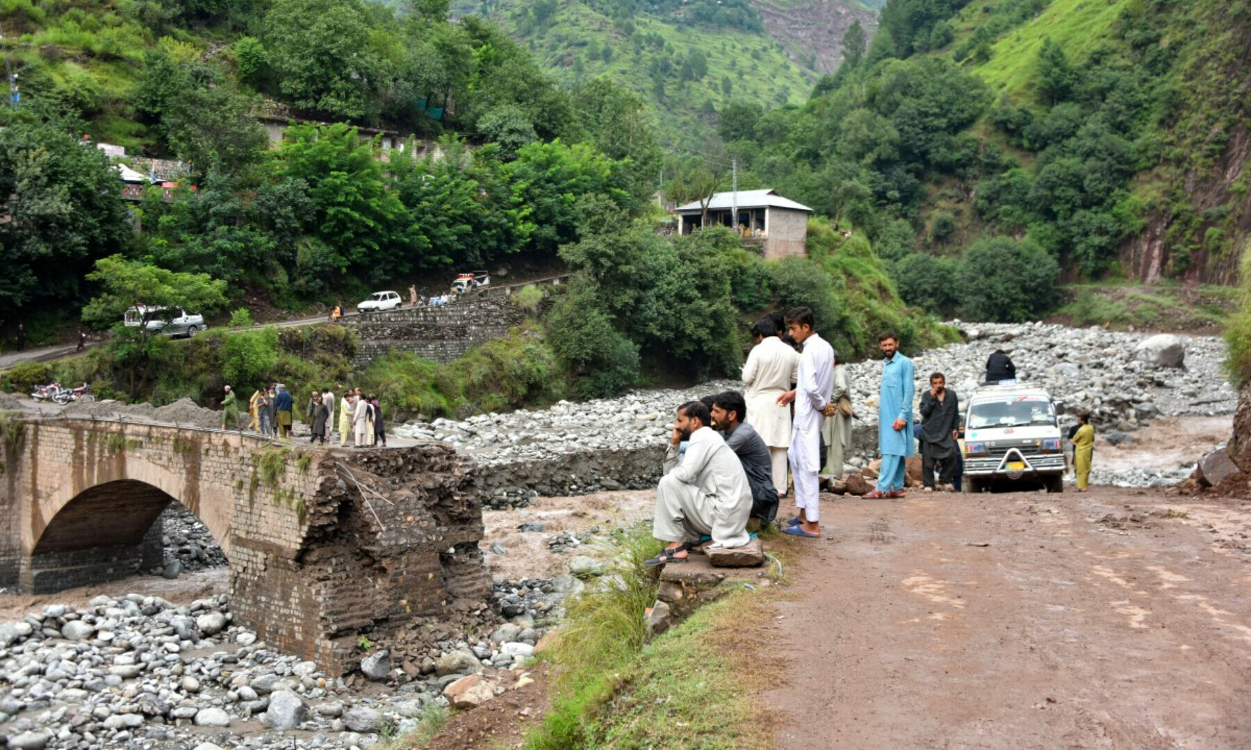  Onlookers gather near a destroyed bridge after flash floods on the outskirts of Muzaffarabad, the capital of Azad Kashmir, on Aug 15, 2025. — AFP 