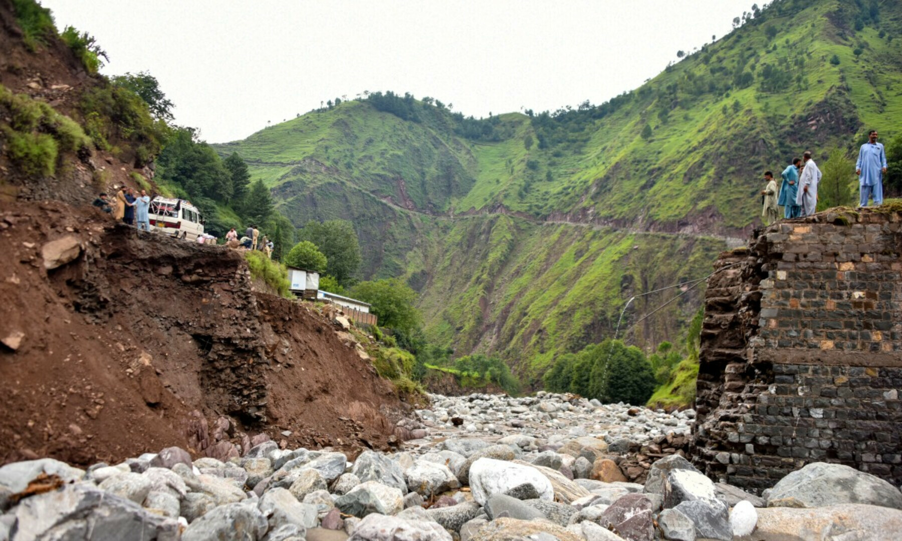 Onlookers gather near a destroyed bridge after flash floods on the outskirts of Muzaffarabad, the capital of Azad Kashmir, on Aug 15, 2025. — AFP 