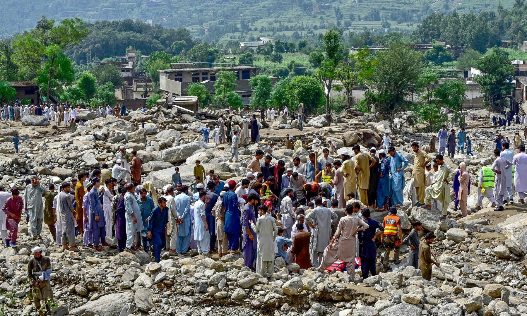خیبرپختونخوا کے ضلع بونیر میں  ریسکیو اہلکار اچانک آنے والے سیلاب کے ایک روز بعد ان کے گھروں کے سامنے سے پتھر ہٹا رہے ہیں &mdash; اے ایف پی