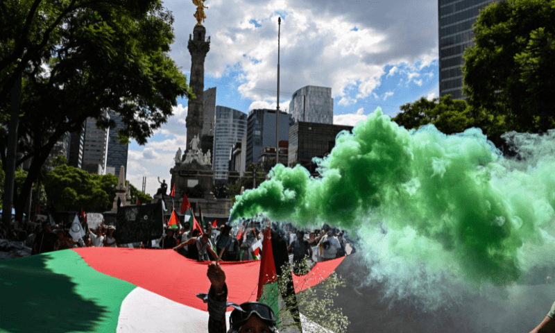  A member of the Global Movement for Palestine holds a green smoke flare during a rally against Israel&rsquo;s actions and the ongoing food shortages in the Gaza strip, in Mexico City on August 17, 2025. &mdash; AFP 