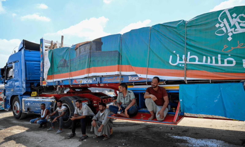  Drivers wait beside a truck loaded with aid for Gaza on the Egyptian side of the Rafah crossing in Rafah on August 18, 2025. &mdash; AFP 