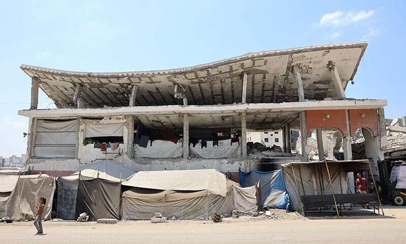 A Palestinian girl walks past a destroyed building in Gaza City on August 18. &mdash; AFP
