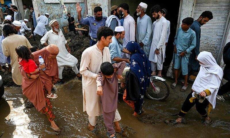 Locals walk along a muddy road, after flash floods hit Buner district in northern Pakistan&rsquo;s mountainous Khyber Pakhtunkhwa province on August 18, 2025. Pakistani rescuers dug homes out from under massive boulders on August 17 as they searched for survivors of flash floods that killed at least 344 people, with more than 150 still missing. &mdash; AFP
