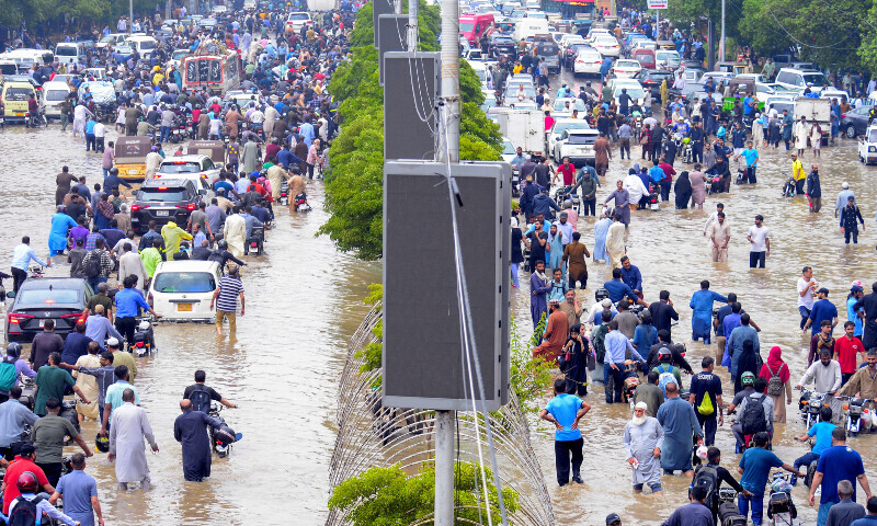 People wade through a flooded Sharea Faisal after the monsoon rain in Karachi, Pakistan, August 19, 2025. — Reuters People wade through a flooded Sharea Faisal after the monsoon rain in Karachi, Pakistan, August 19, 2025. — Reuters