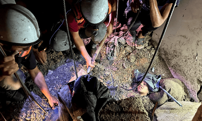 People attempt to rescue Palestinian woman Saja Hamad as she lies trapped under the rubble of a house hit in an Israeli strike, in Nuseirat in the central Gaza Strip on August 20, 2025. &mdash; Reuters