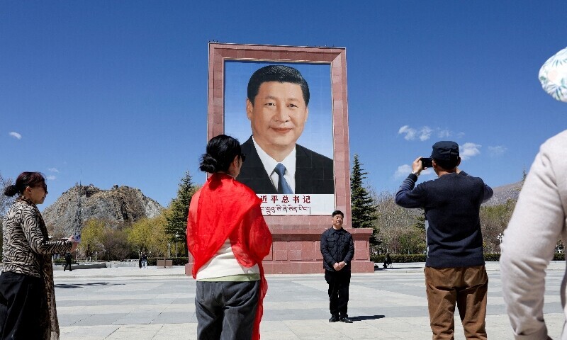 People take photo in front of a large portrait of Chinese President Xi Jinping, during a government-organized tour, at Potala Palace Square in Lhasa, Tibet Autonomous Region, China, March 28, 2025. &mdash; Reuters