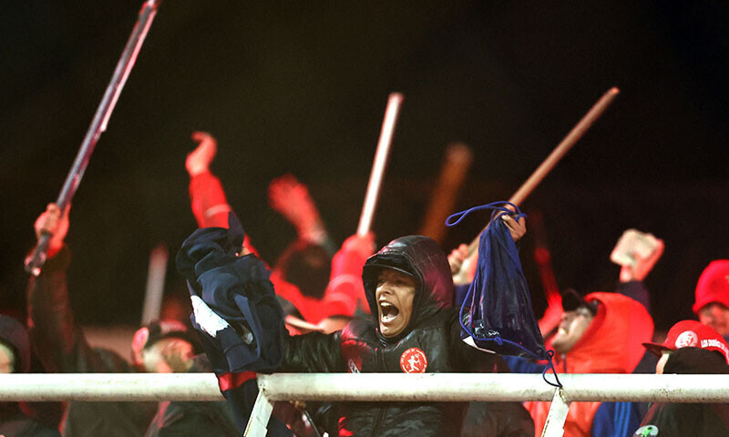 Independiente fans display stolen clothing and brandish sticks at the stands where Universidad de Chile fans were sitting when the Copa Sudamericana football match between Argentina&rsquo;s Independiente and Chile&rsquo;s Universidad de Chile was interrupted at the Libertadores de America stadium in Avellaneda, Buenos Aires province, Argentina, August 20. &mdash; AFP
