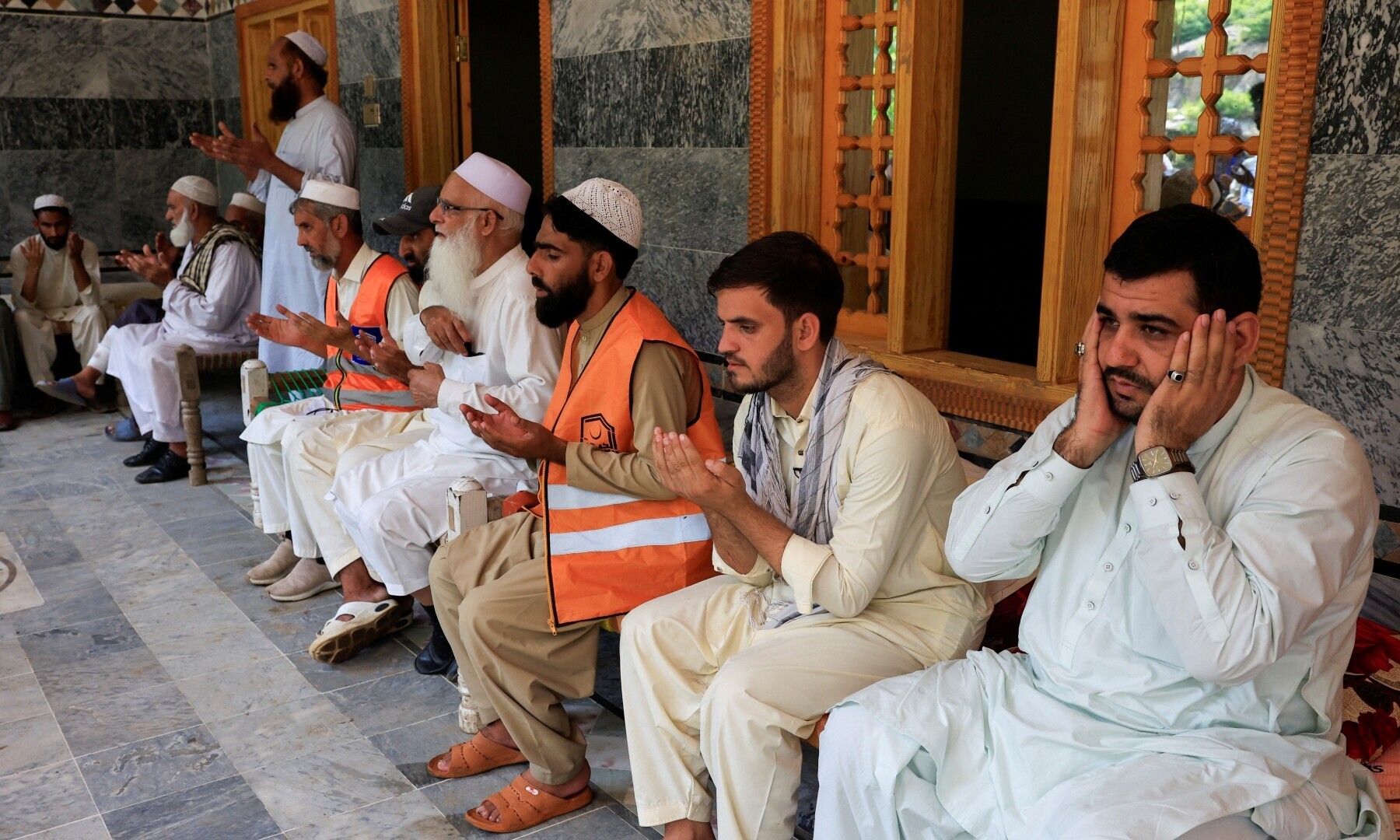 Noor Muhammad sits with guests in a condolance gathering at his 36-room family house which was hit by devastating floods in the mountainous Qadir Nagar village of KP’s Buner district on August 21. — Reuters