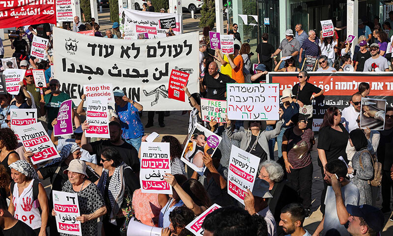 Arab-Israelis and Israeli left-wing activists hold placards and photos of malnourished children during a protest at HaBima square in Tel Aviv, Israel on August 23, against the ongoing conflict and catastrophic humanitarian situation in the Gaza Strip. &mdash; AFP