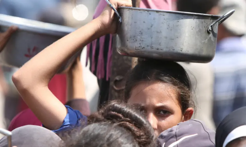  A girl holds a pot as she and other Palestinians wait to receive food from a charity kitchen in Khan Younis, southern Gaza Strip on August 21, 2025. &mdash; Reuters/File 
