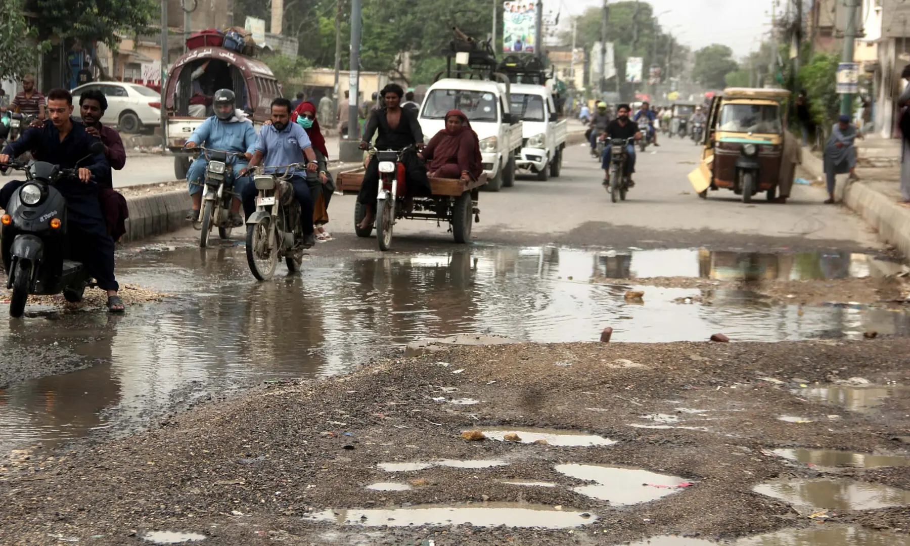 Commuters face difficulties due to
stagnant rainwater resulting from poor drainage, after last week&rsquo;s heavy downpour, at Jahangir Road in Karachi on Aug 24, 2025. &mdash; S.Imran Ali/PPI Images