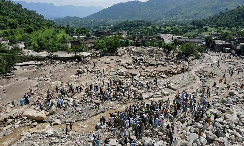 An aerial view shows flood survivors gathered near damaged houses along the banks of a river surrounded by heavy rocks in KP&rsquo;s Buner district on August 17. &mdash; AFP