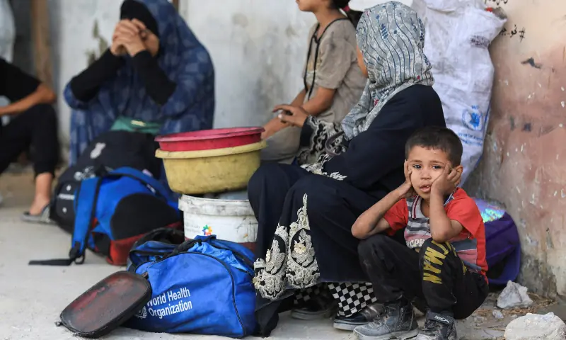  A child looks on as a displaced Palestinian family sits on the ground outside Al-Ahli Arab Hospital after fleeing Israeli strikes during an Israeli military operation, in Gaza City on August 26, 2025. &mdash; Reuters 