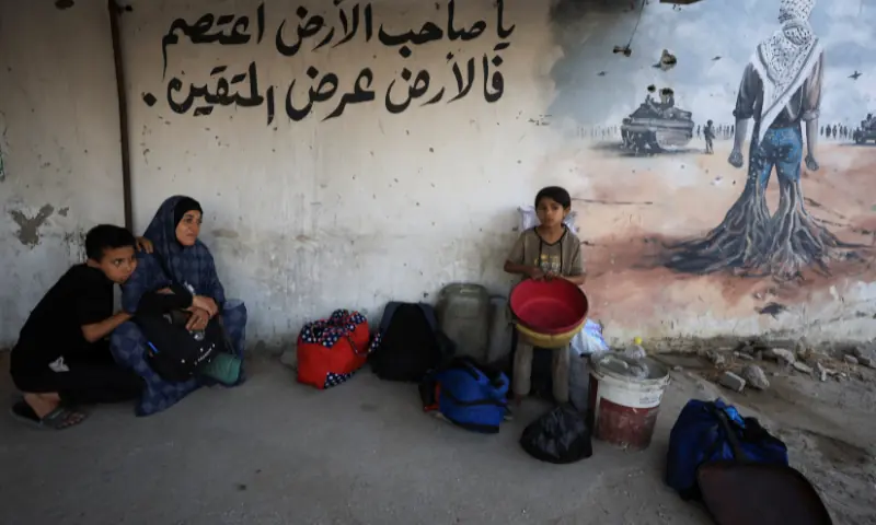  A displaced Palestinian family sits on the ground outside Al-Ahli Arab Hospital after fleeing Israeli strikes during an Israeli military operation, in Gaza City on August 26, 2025. &mdash; Reuters 
