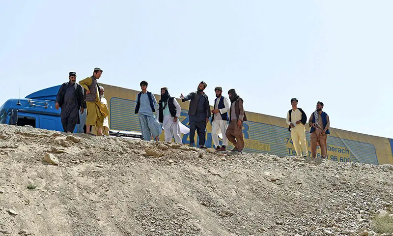 Afghans stand at the accident site after a passenger bus overturned on the Kabul-Kandahar highway, on the outskirts of Maidan Wardak province in Afghanistan on August 27. — AFP Afghans stand at the accident site after a passenger bus overturned on the Kabul-Kandahar highway, on the outskirts of Maidan Wardak province in Afghanistan on August 27. — AFP